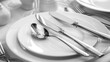 Shiny stainless steel cutlery set beside pristine white ceramic dinnerware, creating a sophisticated dining setup.