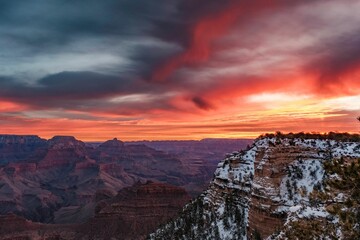 Stunning landscape featuring two white clouds in a vibrant blue sky over a dramatic, dry cliff