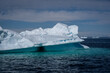 Pittoresker Eisberg treibt in der Diskobucht bei Ilulissat, durch den Sonnenschein sieht man die türkise Farbei im Wasser