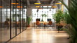 Softly blurred office space bathed in warm light, with green plants, suggesting a modern and dynamic work environment