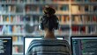 © AhmadTriwahyuutomo - female student prepares for UX design exams, studying web design in library, captured in over-the-shoulder shot