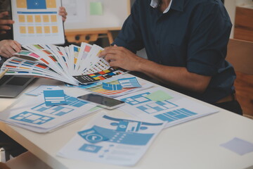 Close up ux developer and ui designer use augmented reality brainstorming about mobile app interface wireframe design on desk at modern office.Creative digital development agency