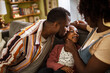 © Marko Geber - Loving African American parents playing with their child on the couch