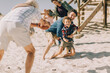 © Marko Geber - Multigenerational family having fun playing football on the beach