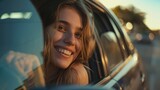 Fototapeta  - Smiling young woman leaning out of car window