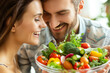 A joyful couple tasting a delicious dish filled with colorful vegetables, highlighting their commitment to a healthy lifestyle through food.
