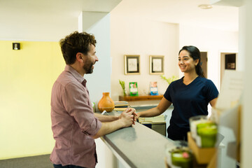 Cheerful man smiling at the nurse at the alternative medicine clinic