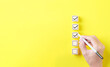 © Supatman - Checklist concept. Person using a black ink pen to correct sign and tick check mark on wooden block with copy space for the checklist on yellow background. Business survey questionnaire, exam process,
