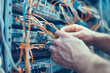 © MarGa - Close-Up of Technician's Hands Working with Network Wires and Servers in Data Center