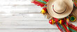 a sombrero with maracas on white wooden background