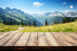 Wooden table top on blur mountain and a meadow with flowers and a path. View of copy space