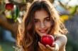Beautiful woman extending her hand with an apple towards viewer.