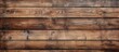 A closeup of a brown hardwood wall with a row of wooden planks creating a rectangle pattern. The wood stain enhances the natural beauty of the wood