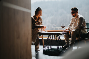 Poster - Two friends laugh and bond over a classic board game of backgammon with a glass of wine, indoors with a beautiful scenic backdrop.