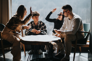 Poster - A joyful gathering of young adults engaged in a card game, sharing laughter and high-fives in a cozy indoor setting.