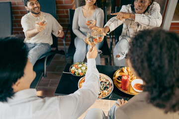 Wall Mural - Close up of happy friends is drinking wine and clinking glasses having holiday party at home terrace