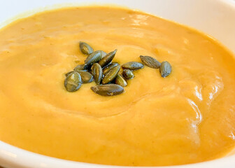 Wall Mural - A bowl of squash soup topped with toasted pumpkin seeds