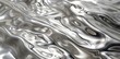 Shiny silver fabric featuring a chic wave pattern. Reflective and modern textile design.