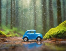 A Blue Toy Car Amidst The Serene Ambiance Of A Rainy Forest, Igniting The Imagination And Inviting Viewers To Embark On A Whimsical Journey Through Nature