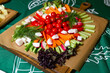 Fresh Vegetable Crudités Platter on Wooden Board. Colorful vegetable crudites artfully arranged on a wooden cutting board with a variety of dips for healthy snacking.