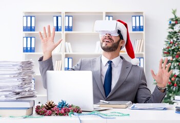 Wall Mural - Young businessman celebrating christmas in the office