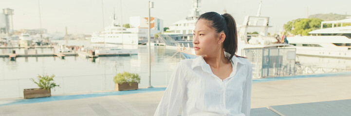 Poster - Young woman resting on the pier of the seaport, Panorama