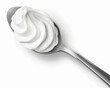 Spoon with whipped cream isolated on white background.