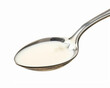 Spoon of milk isolated on white background.