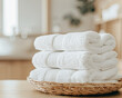 close up of stack of white towels in wicker basket on table in bathroom