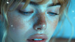 A woman with bangs and blonde hair and freckles closed her eyes and sat sideways, with blue and soft lights falling on her face.
