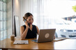© apichat - Businesswoman on Phone Call in Bright Office