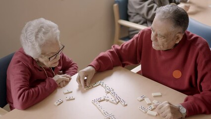 Wall Mural - Senior man playing dominoes with old friend in a geriatric