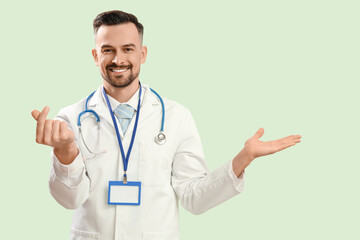 Sticker - Male doctor making heart with his fingers on green background