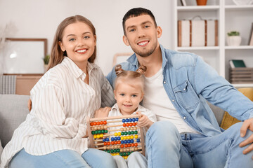 Wall Mural - Happy parents and their little daughter with abacus at home