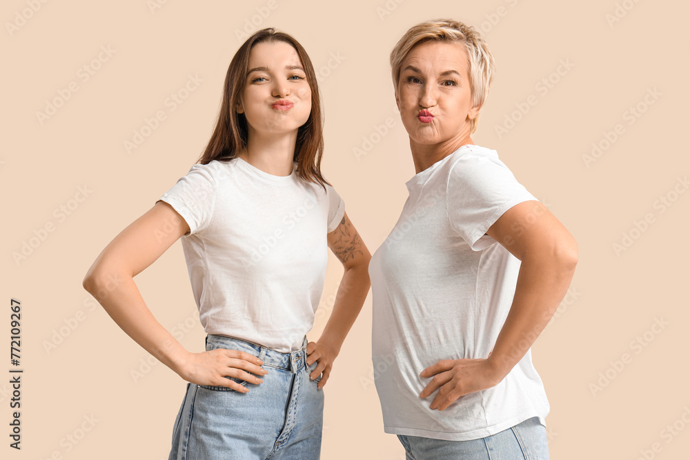 Beautiful women doing face building exercise on beige background