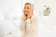 © Pixel-Shot - Mature woman doing face building exercise in bedroom
