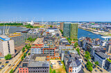 Fototapeta Desenie - Antwerp cityscape, aerial panoramic view of Antwerp city Eilandje quarter neighborhood with port area, water canals, windmills on skyline horizon, panorama of Antwerpen, Flemish Region, Belgium