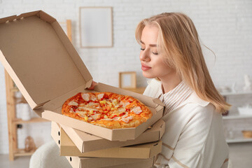 Canvas Print - Young woman holding boxes with tasty pizza at home