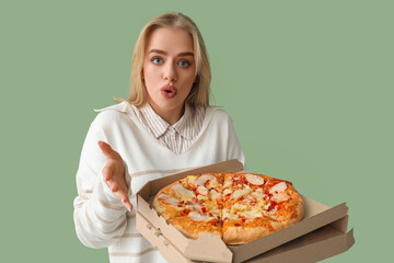 Wall Mural - Surprised beautiful woman with tasty pizza on green background