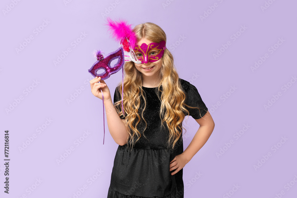 Funny little girl with carnival masks on lilac background