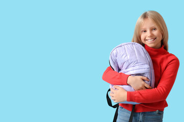 Wall Mural - Cute schoolgirl with backpack on blue background