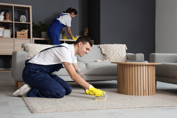 Poster - Male janitor cleaning carpet with brush in room