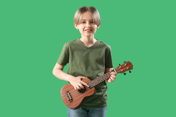 Canvas Print - Cute little boy with ukulele on green background