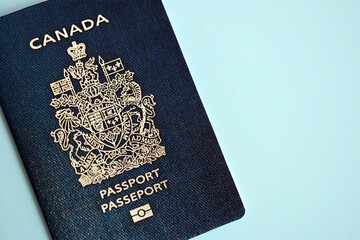 Wall Mural - Canadian passport on blue background close up. Tourism and citizenship concept