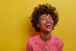 Happy Attractive African American Woman Laughing with Excitement in Colorful Pink Clothes on Yellow Background