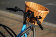 Staitionenry Blue Bicycle With A Wicker Shopping Basket Attached To Handlebars