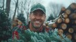 A smiling man carries a freshly cut Christmas tree in the forest. Young lumberjack