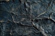 The image is of a black and grey rock with cracks and holes. The texture of the rock is rough and jagged, giving it a sense of age and wear. Scene is one of ruggedness and toughness
