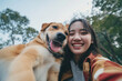 cute asian girl takes a selfie with her dog	