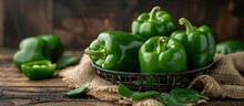 A Basket Filled With Fresh Green Peppers Sitting On A Wooden Table.